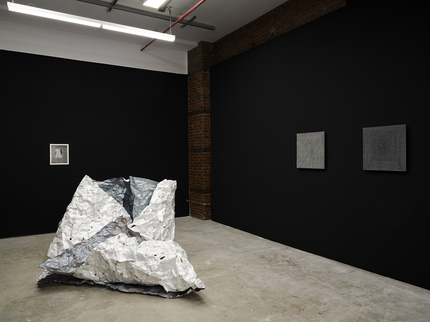 *arms ache avid aeon: Nancy Brooks Brody / Joy Episalla / Zoe Leonard / Carrie Yamaoka: fierce pussy amplified: Chapter Eight,* Curated by Jo-ey Tang, 2025, installation view at Participant Inc, NYC, pictured: Zoe Leonard, *Untitled*, 2016, gelatin silver print, and Joy Episalla,* foldtogram (chromo white/blue, winter 40’ x 50”)*, 2025, light sensitive chromogenic object, and Nancy Brooks Brody,* Glory Hole*, (vibgyor) white on black, 2012, oil on venetian plaster on wood, and Nancy Brooks Brody, *Glory Hole,* (vibgyor) grey on black, 2018, oil on venetian plaster on wood. Photos by Studio Kukla
